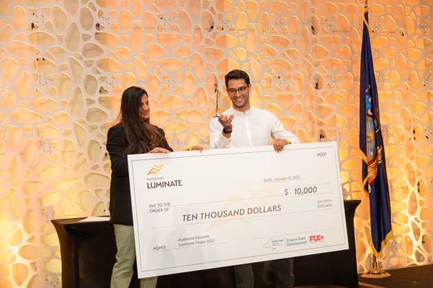 Federico Acosta, Custom Surgical CEO, receiving large check from Luminate Awards.